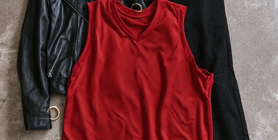 Basketball game outfits for women flat lay with a black leather jacket, red mesh jersey top, black jeans, white sneakers and a small black crossbody bag