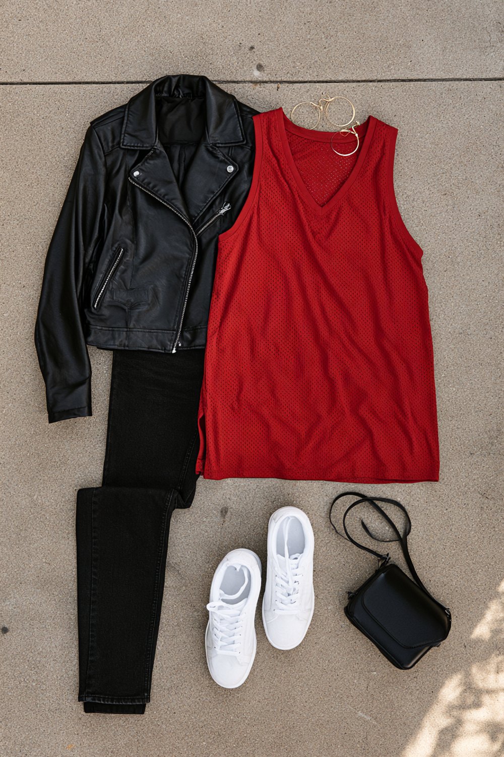 Black jeans, red tank, leather moto jacket, white sneakers and a small crossbody for a night at the arena