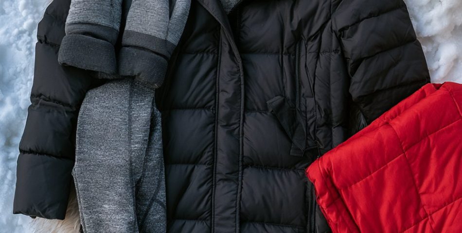 Hockey mom outfits flat lay with a long black puffer coat, cream knit beanie, mittens, coffee tumbler and warm boots