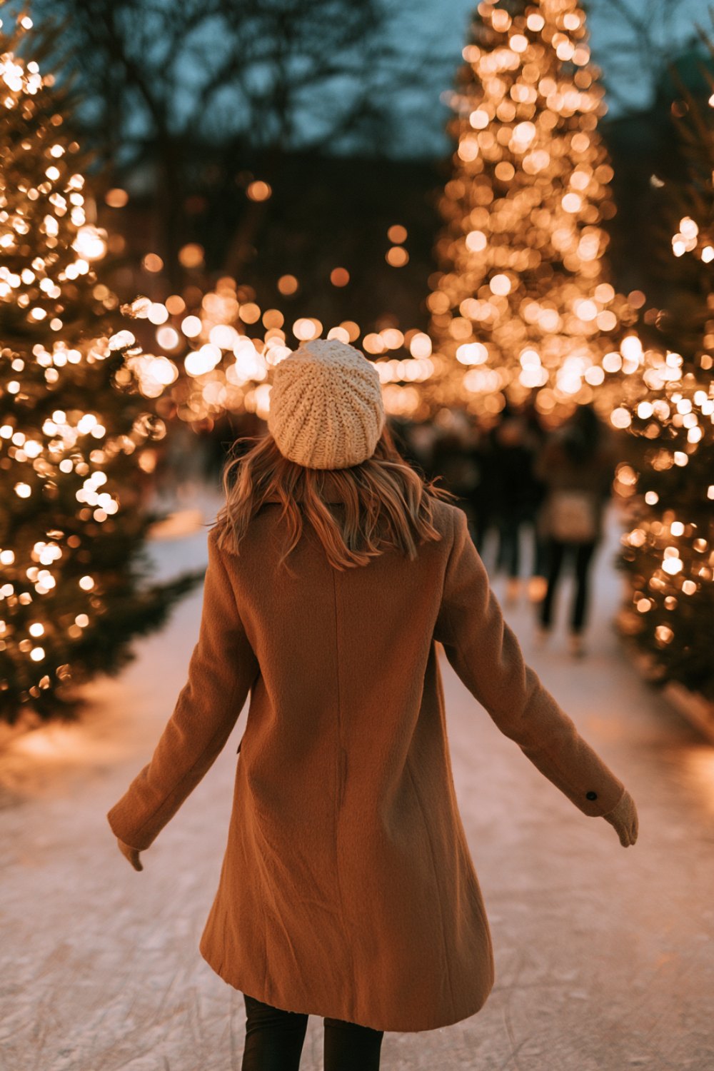 Skater from behind gliding through a festive outdoor rink in a camel coat and black leggings
