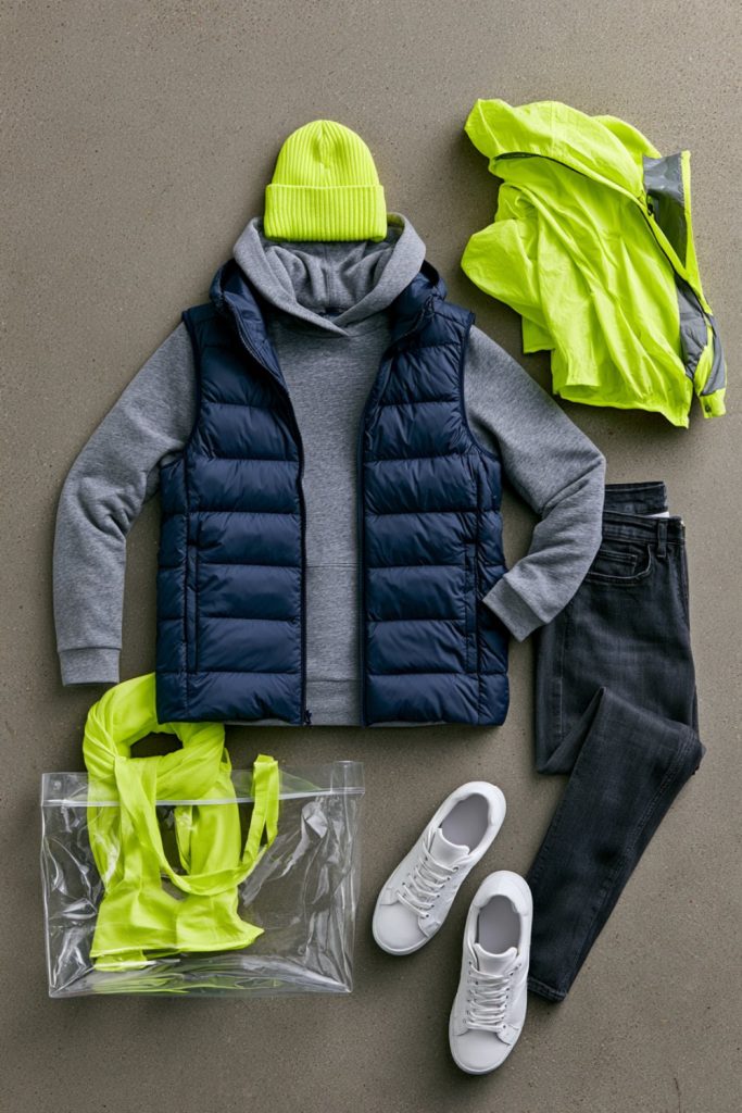 Grey hoodie under a navy vest with a lime beanie and rain shell for a damp Seattle game