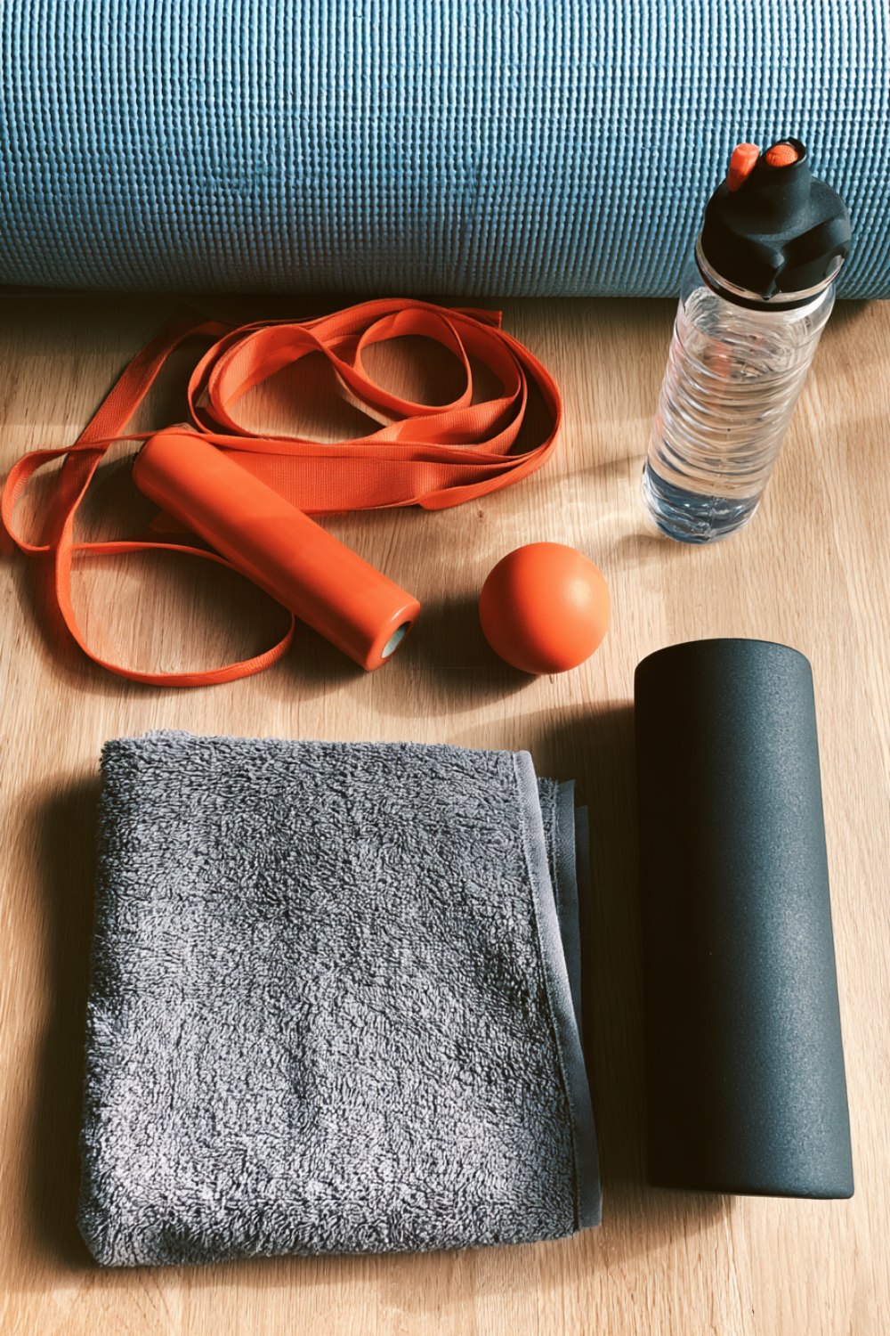 Stretching strap, foam roller, massage balls and a towel laid out for a bedtime routine