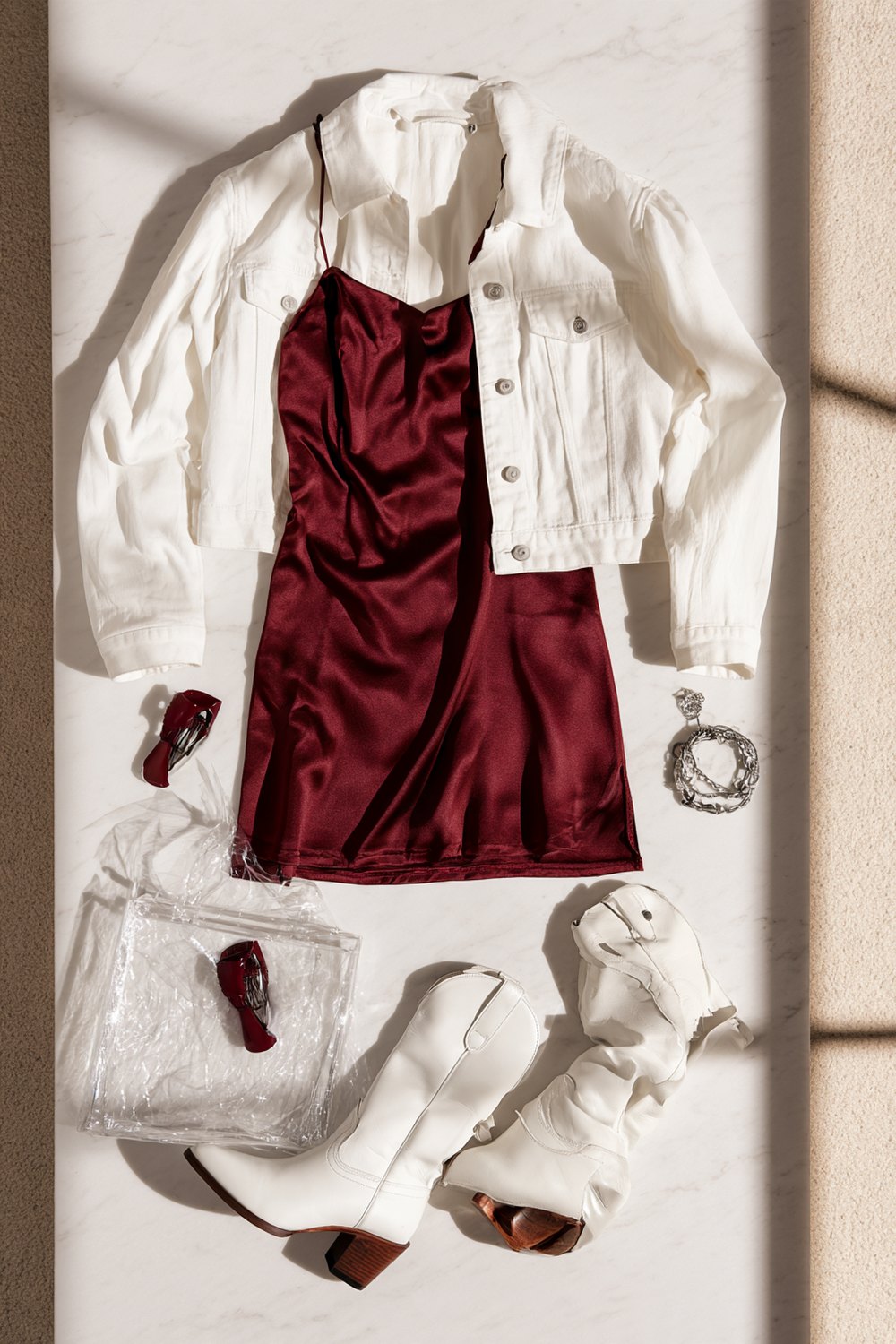 Maroon and white game day outfit laid out on marble with a clear stadium bag and maroon claw clip